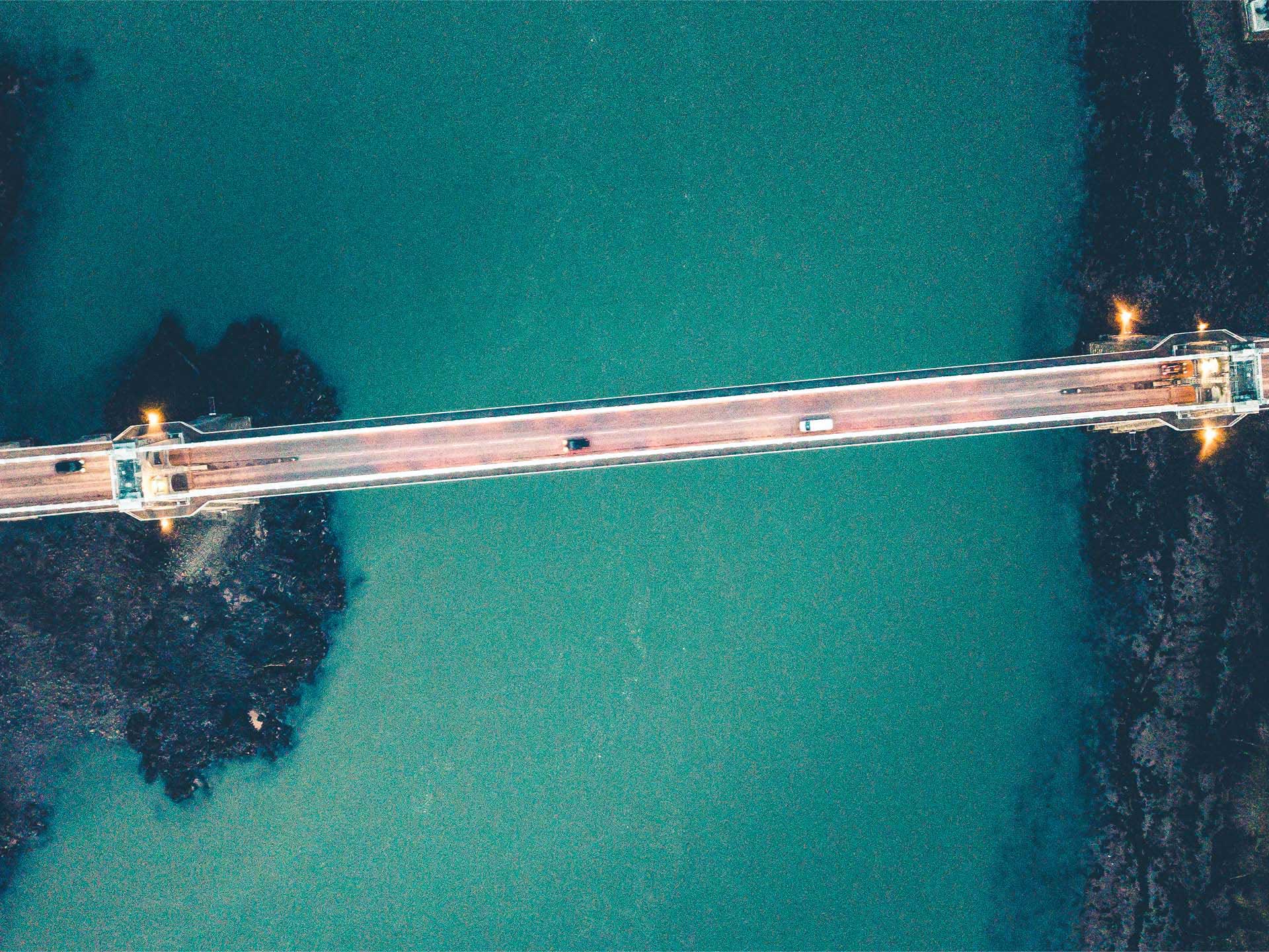 Drrone captured shot of Menai Bridge from above as cars cross over.