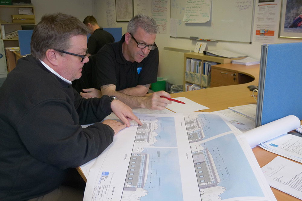 John Evans and Graham Wolfenden looking over blueprints